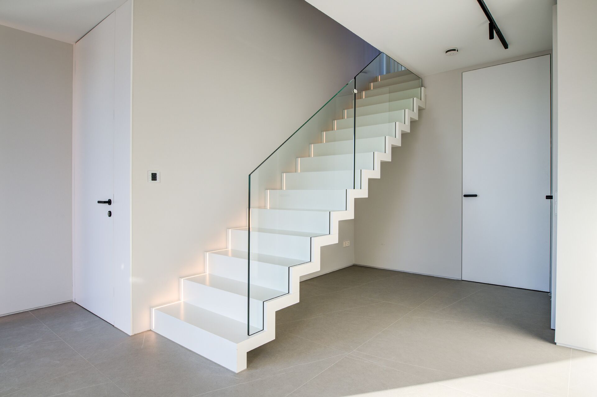 Faltwerktreppe in weiß mit Glasgeländer und LED Beleuchtung in den Stufen von STOCKWERK-Treppen