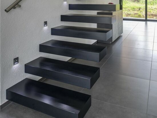 Gerade Kragarmtreppe in Corian "deep nocturne", frei schwebende beleuchtete Treppenstufen
